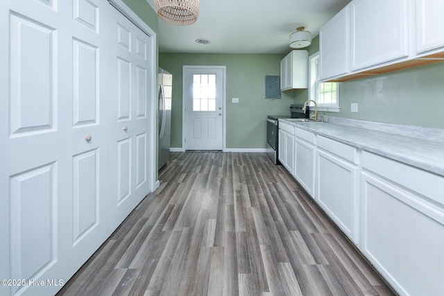 190 NC Highway 32, Sunbury, NC 27979 - kitchen with appliances with stainless steel finishes, a sink, white cabinetry, dark wood finished floors, and a chandelier