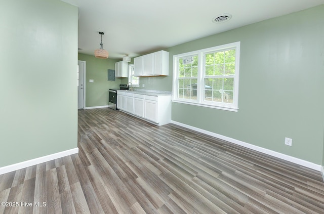 190 NC Highway 32, Sunbury, NC 27979 - kitchen with white cabinets, baseboards, light countertops, wood finished floors, and stainless steel electric stove
