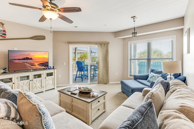 120 SE 58th St Unit 2104, Oak Island, NC 28465 - living room featuring plenty of natural light, baseboards, ceiling fan, and light carpet