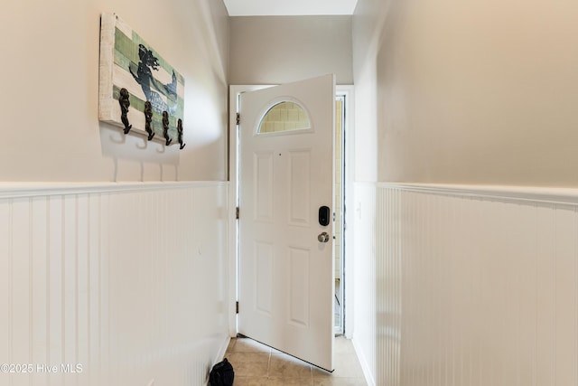 120 SE 58th St Unit 2104, Oak Island, NC 28465 - doorway with light tile patterned floors and wainscoting