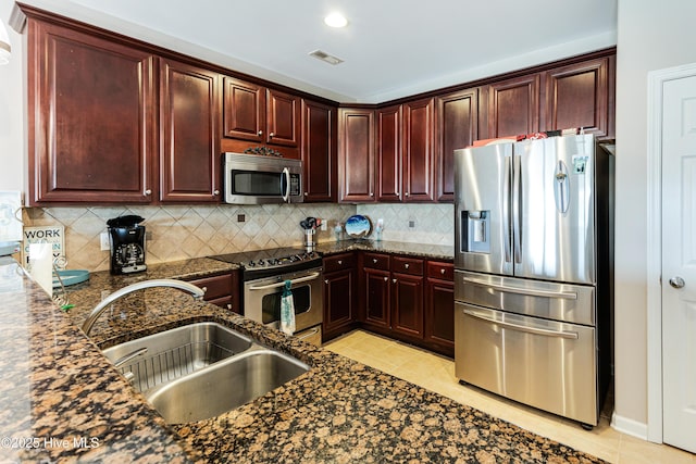120 SE 58th St Unit 2104, Oak Island, NC 28465 - kitchen with decorative backsplash, visible vents, dark brown cabinets, a sink, and stainless steel appliances