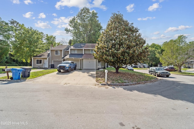 view of front of house featuring driveway, a residential view, and a garage