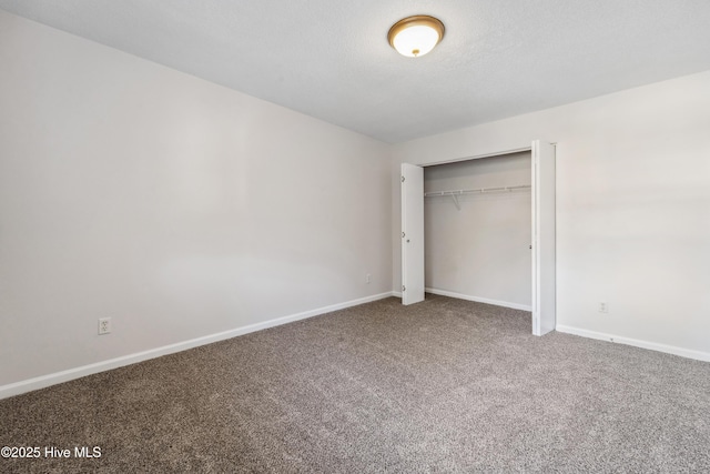 unfurnished bedroom with baseboards, carpet flooring, and a closet