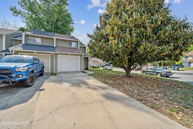 view of front of property with a garage, a shingled roof, and driveway