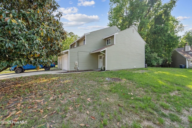 exterior space featuring concrete driveway, a front yard, and a garage