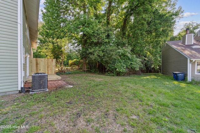 view of yard with fence and central AC