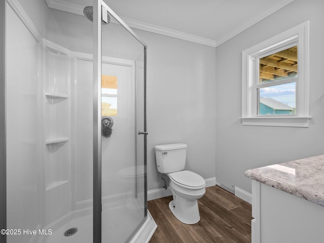 full bath with a shower stall, baseboards, toilet, ornamental molding, and wood finished floors