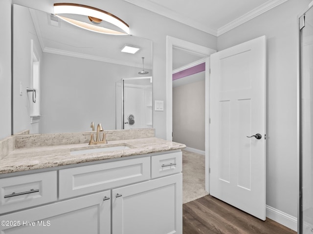 full bathroom with baseboards, wood finished floors, crown molding, and vanity
