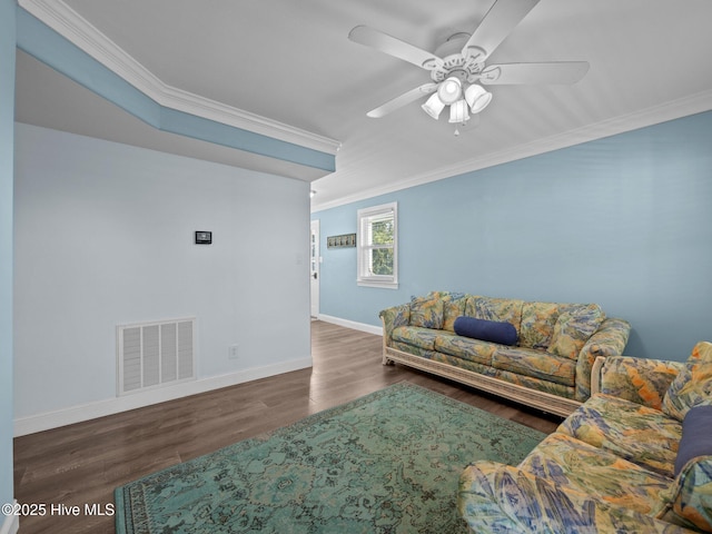 living area with wood finished floors, ceiling fan, baseboards, visible vents, and crown molding