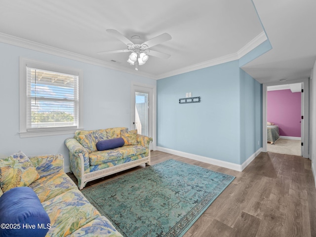 living area featuring ornamental molding, wood finished floors, and plenty of natural light