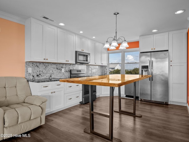kitchen featuring an inviting chandelier, decorative backsplash, stainless steel appliances, white cabinetry, and dark wood-type flooring