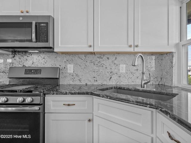 kitchen with white cabinetry, backsplash, appliances with stainless steel finishes, and a sink
