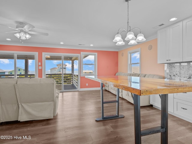 unfurnished dining area with recessed lighting, wood finished floors, a healthy amount of sunlight, and crown molding