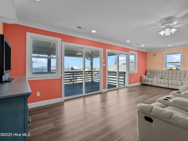living room with visible vents, ceiling fan, ornamental molding, and baseboards