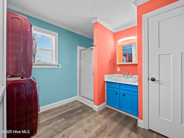 full bath with wood finished floors, vanity, ornamental molding, and a stall shower