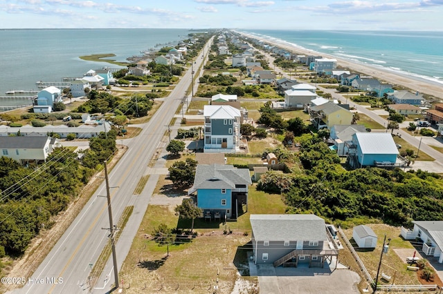 drone / aerial view with a beach view, a residential view, and a water view
