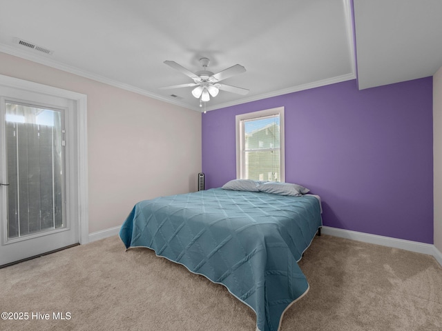 carpeted bedroom featuring baseboards, visible vents, ceiling fan, and crown molding
