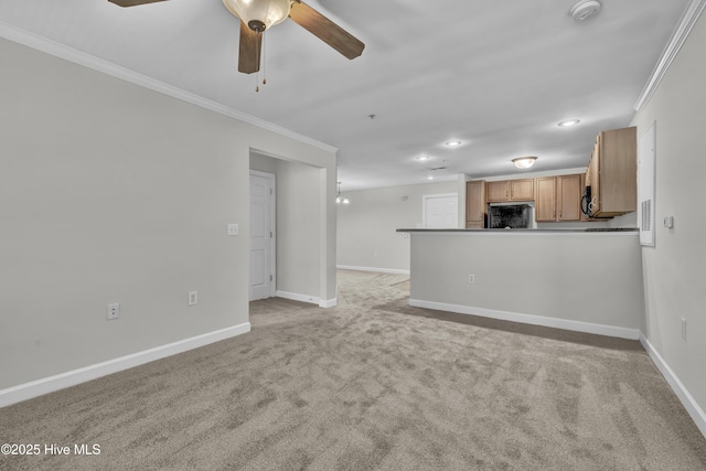 unfurnished living room featuring baseboards, ornamental molding, ceiling fan, and light carpet