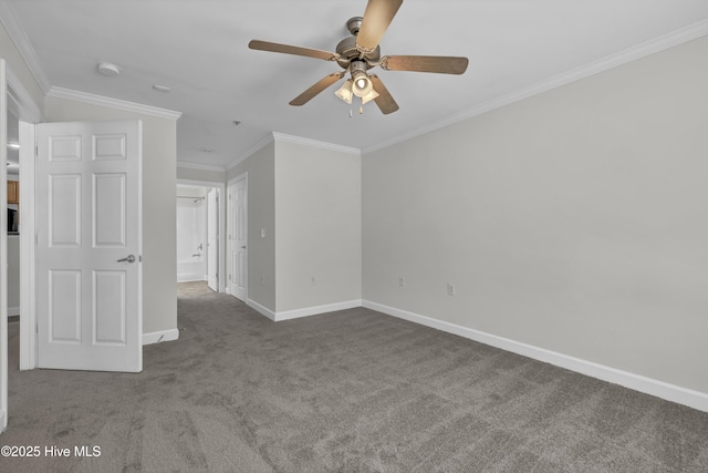 carpeted spare room with crown molding, baseboards, and ceiling fan