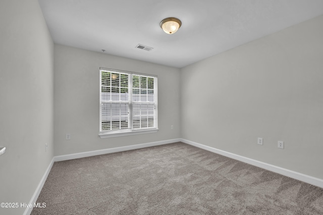 unfurnished room with baseboards, carpet flooring, and visible vents
