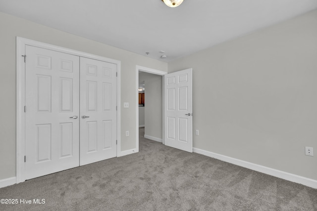 unfurnished bedroom with carpet floors, baseboards, and a closet