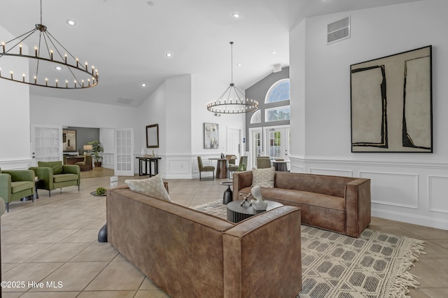 living room featuring a decorative wall, a chandelier, recessed lighting, light tile patterned floors, and visible vents