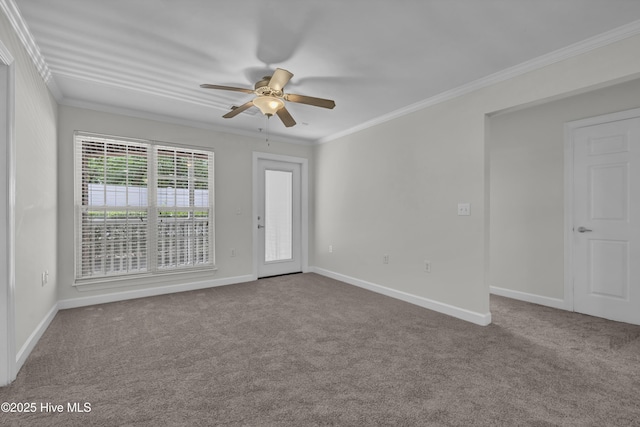 carpeted spare room with crown molding, baseboards, and ceiling fan