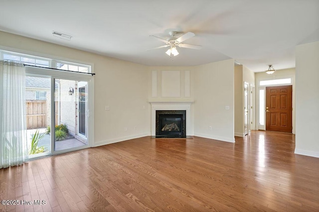 1008 Garden Club Way, Leland, NC 28451 - unfurnished living room featuring ceiling fan, wood finished floors, a high end fireplace, and baseboards