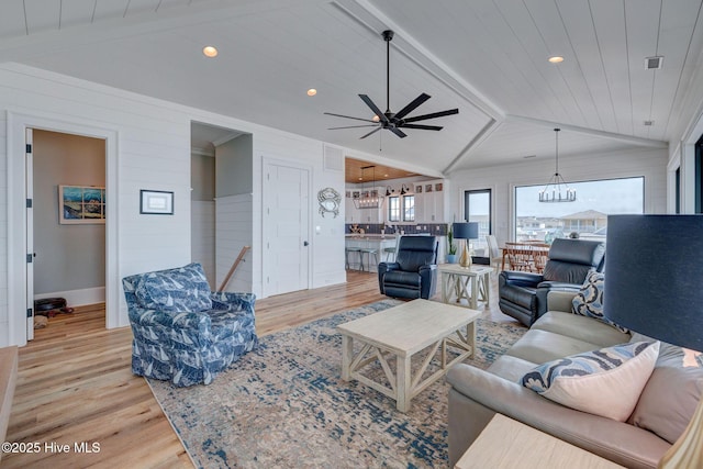 living room with wooden ceiling, baseboards, light wood finished floors, vaulted ceiling with beams, and ceiling fan with notable chandelier