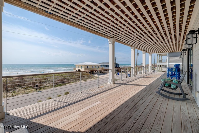 deck featuring a view of the beach and a water view