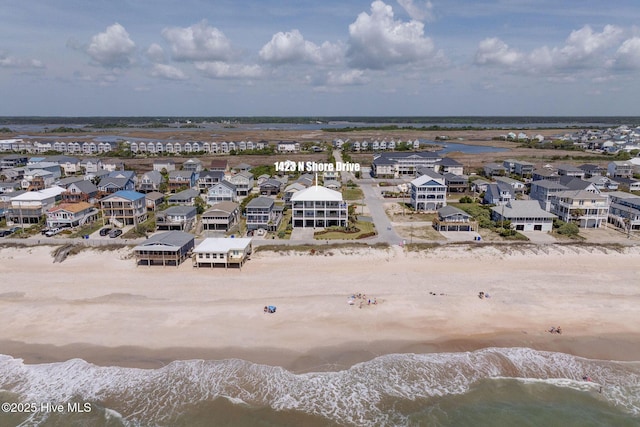 drone / aerial view featuring a residential view, a view of the beach, and a water view