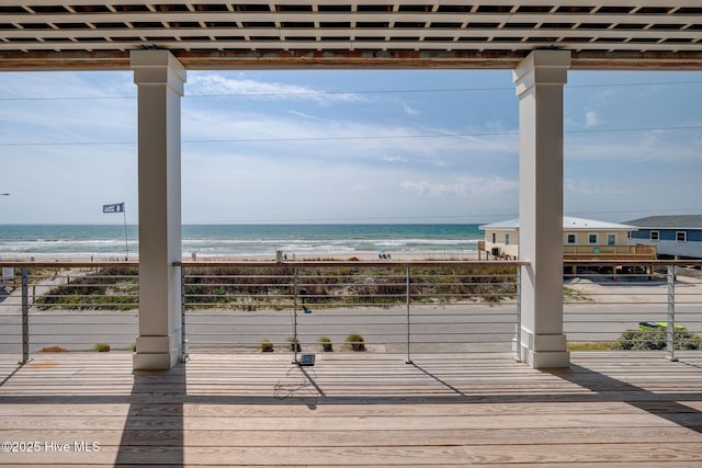 deck with a view of the beach and a water view