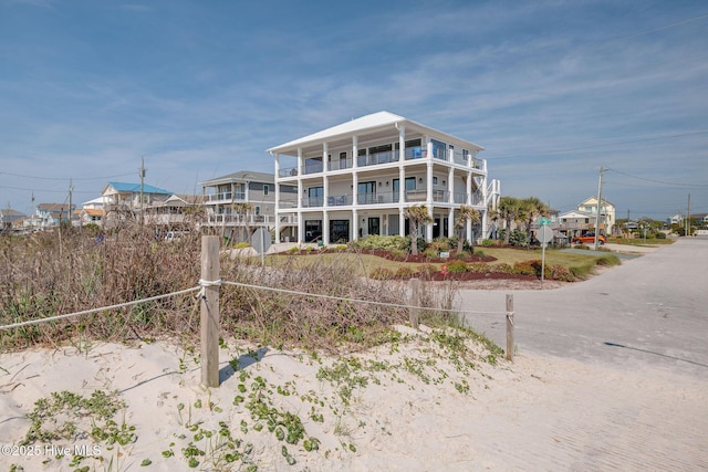 rear view of property featuring driveway and a balcony