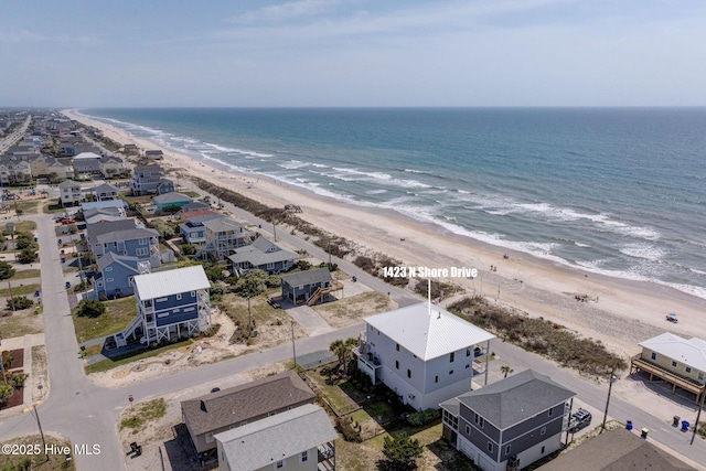 drone / aerial view featuring a beach view and a water view