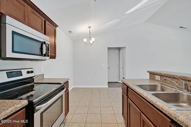 kitchen with visible vents, appliances with stainless steel finishes, vaulted ceiling, a sink, and a notable chandelier