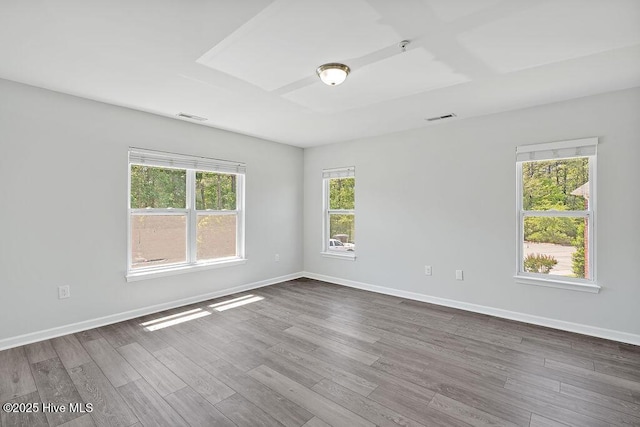 empty room with baseboards, dark wood finished floors, and visible vents
