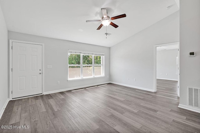 unfurnished living room with ceiling fan, baseboards, wood finished floors, vaulted ceiling, and visible vents