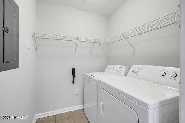 laundry room featuring laundry area, electric panel, washing machine and dryer, light tile patterned floors, and baseboards