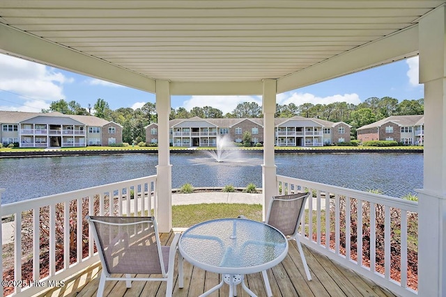 wooden terrace with a residential view and a water view
