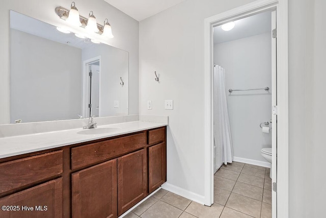 bathroom featuring tile patterned flooring, baseboards, toilet, and vanity
