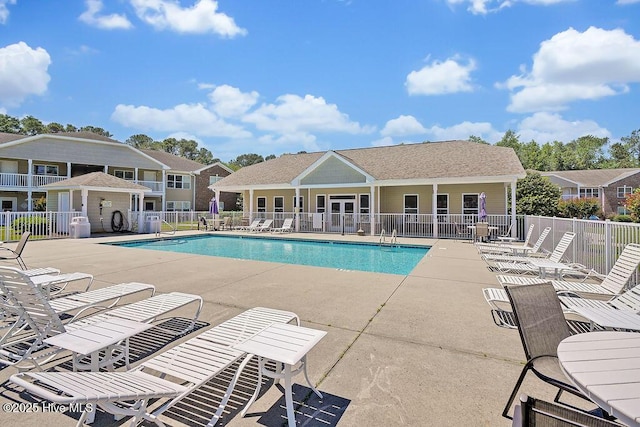 community pool with fence and a patio area