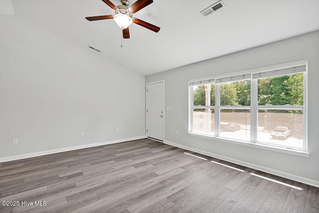 unfurnished room with a ceiling fan, baseboards, visible vents, and wood finished floors
