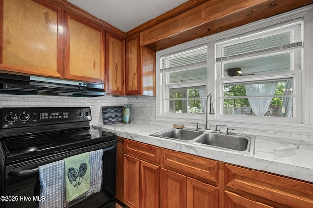 kitchen with decorative backsplash, under cabinet range hood, light countertops, a sink, and black electric range oven