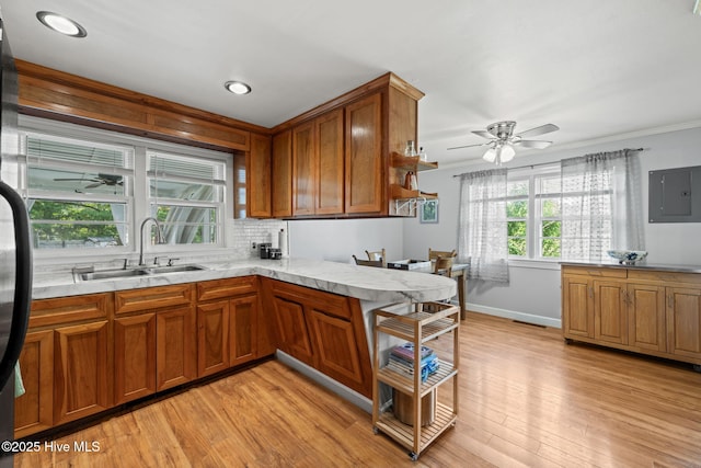 kitchen featuring a ceiling fan, brown cabinetry, and a sink