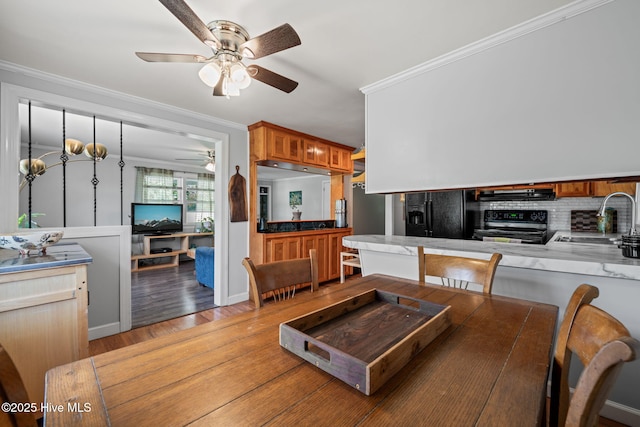dining space with ornamental molding, light wood finished floors, and ceiling fan