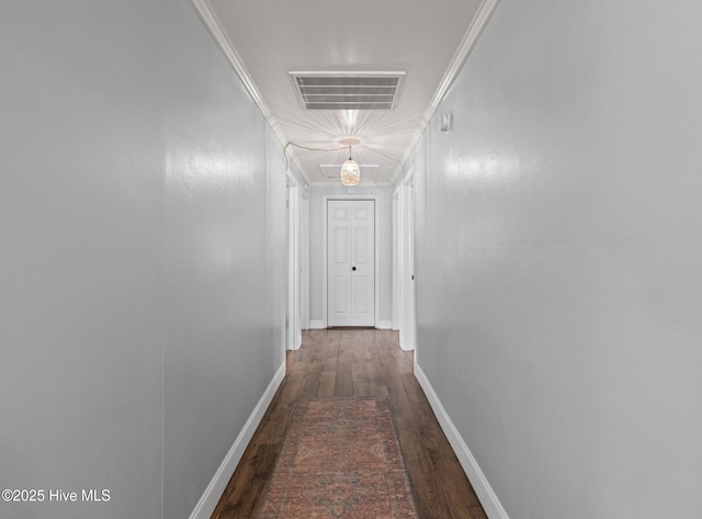 hall with baseboards, visible vents, attic access, and wood finished floors