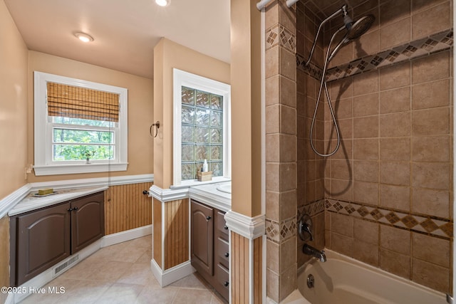 bathroom with bathtub / shower combination, tile patterned floors, a wainscoted wall, vanity, and visible vents
