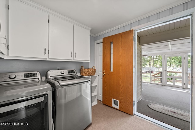 washroom with washing machine and clothes dryer, cabinet space, crown molding, and light carpet