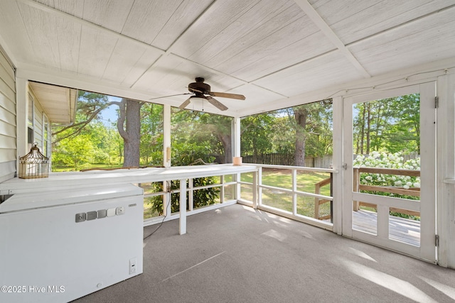unfurnished sunroom featuring a ceiling fan