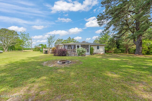 view of yard featuring a sunroom and a fire pit